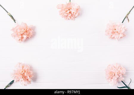 Einfach flach Rahmen rosa Knospen auf weissem Holztisch mit leeren Raum in Mitte für Design, Ansicht von oben. Stockfoto
