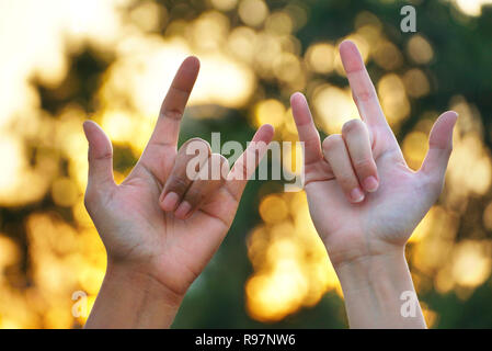 Zwei Menschen zeigen, stumme Sprache hand Liebe mit blur bokeh Hintergrund Stockfoto