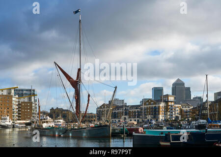 Old Yacht und narrowoats in Limehouse Basin festgemacht, East London, UK, mit Canary Wharf im Hintergrund Stockfoto