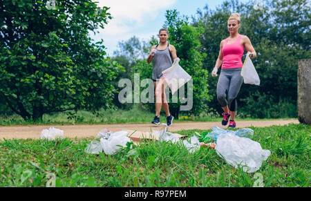 Halde und zwei Mädchen tun plogging Stockfoto