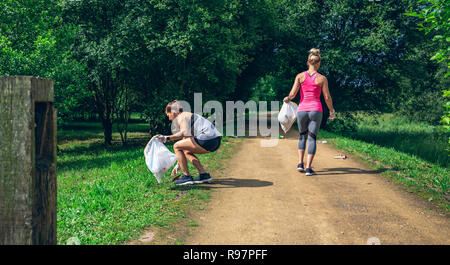 Zwei Mädchen auf dem Rücken tun plogging Stockfoto