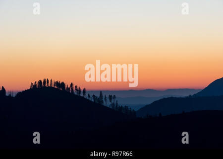 Berg und Baum Silhouetten bei Sonnenuntergang im Yosemite National Park, Kalifornien Stockfoto