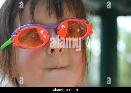 Kleines Mädchen mit bunten Fischen Sonnenbrille Stockfoto