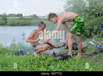 Kovrov, Russland. 15. Juni 2013. Nachbarschaften der Stadt Kovrov, See (Teich) Gidromut. Teens kindle Lagerfeuer kochen Fisch Stockfoto