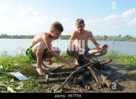 Kovrov, Russland. 15. Juni 2013. Nachbarschaften der Stadt Kovrov, See (Teich) Gidromut. Teens kindle Lagerfeuer kochen Fisch Stockfoto