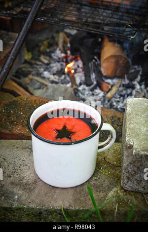 Wein in einem eisen Becher auf in der Nähe des FIRE Stockfoto