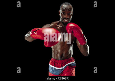 Die Hände der Boxer über schwarzen Hintergrund. Stärke, Angriff und Motion Konzept. Passen afrikanische amerikanische Modell in Bewegung. Afro muskulöse Athleten im Sport uniform. Sportliche Mann beim Boxen Stockfoto