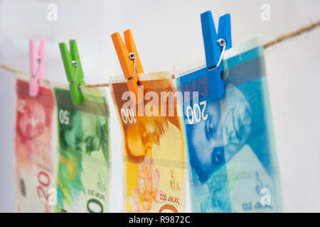 Geldwäsche - neue israelische Schekel an einem Seil aufgehängt Stockfoto