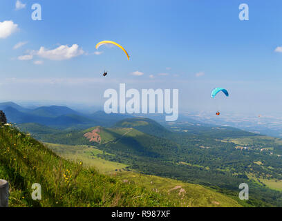 Gleitschirme, der in der Mitte der Landschaft Vulkane und Berge fliegen. Stockfoto