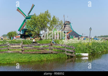 Touristen zu Fuß entlang der traditionellen holländischen Windmühlen in Zaanse Schans in Niederlande Stockfoto