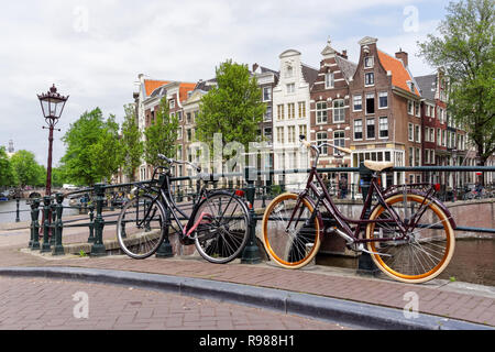 Niederländische Fahrräder am Kanal in Amsterdam, Niederlande geparkt Stockfoto