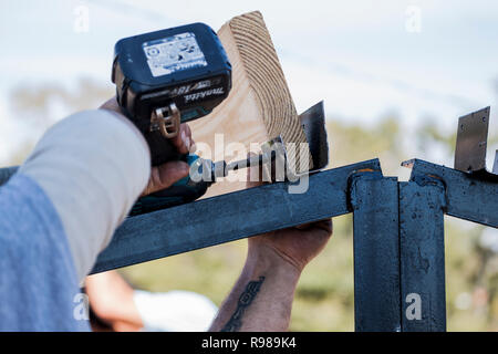 Mann mit der Bohrmaschine auf Metall Truss Stockfoto