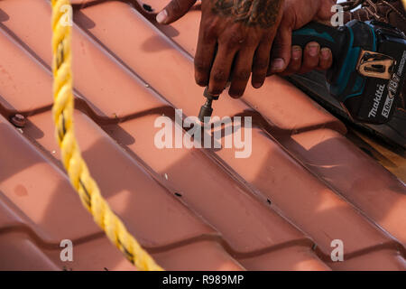 Mann mit elektrischen Bohrmaschine zu reparieren Roofing Stockfoto