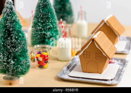 Kinder Partei kleine Lebkuchenhäuser mit Bonbons zu verzieren. Stockfoto