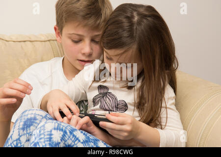 Digitale Gerät, Tablet-PC, iPad, älterer Bruder, jüngere Schwester mit Social Media, moderne Technologie Stockfoto