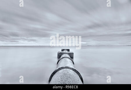 Regenwasserversickerung Rohr in die Bucht führenden mit Wolken, Langzeitbelichtung mit Wasser Stockfoto