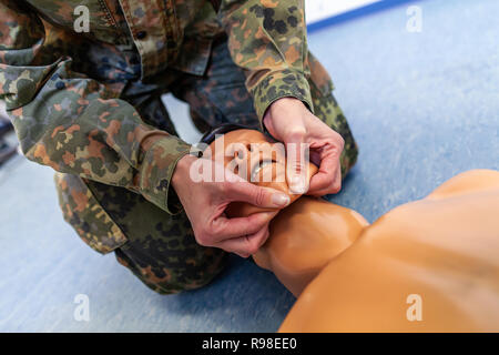 Paramedizinische Soldat Praktiken eine medizinische Ausbildung auf eine Marionette Stockfoto