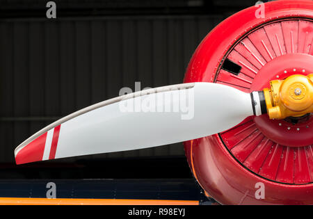 Detail der roten und weißen Flugzeug Propeller, orange und rot Motor und die Verkleidung vor einem schwarzen Hintergrund Stockfoto