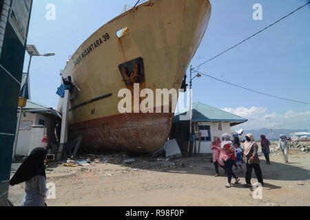 Bewohner bewegen in der Nähe von KM Sabuk Nusantara, die an Land durch den Tsunami in Wani, Oktopus, Central Sulawesi, Samstag (3. November 2018) abgestürzt. Stockfoto