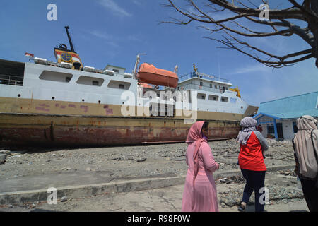 Bewohner bewegen in der Nähe von KM Sabuk Nusantara, die an Land durch den Tsunami in Wani, Oktopus, Central Sulawesi, Samstag (3. November 2018) abgestürzt. Stockfoto