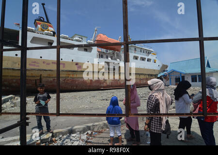 Bewohner bewegen in der Nähe von KM Sabuk Nusantara, die an Land durch den Tsunami in Wani, Oktopus, Central Sulawesi, Samstag (3. November 2018) abgestürzt. Stockfoto