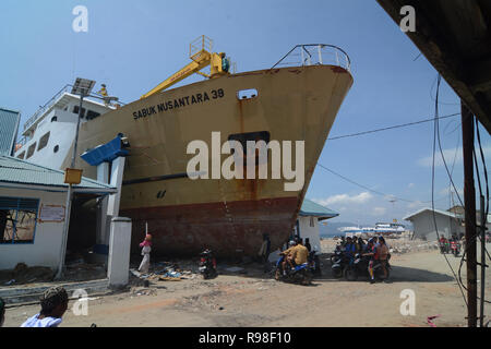 Bewohner bewegen in der Nähe von KM Sabuk Nusantara, die an Land durch den Tsunami in Wani, Oktopus, Central Sulawesi, Samstag (3. November 2018) abgestürzt. Stockfoto