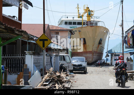 Bewohner bewegen in der Nähe von KM Sabuk Nusantara, die an Land durch den Tsunami in Wani, Oktopus, Central Sulawesi, Samstag (3. November 2018) abgestürzt. Stockfoto