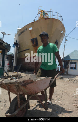 Bewohner bewegen in der Nähe von KM Sabuk Nusantara, die an Land durch den Tsunami in Wani, Oktopus, Central Sulawesi, Samstag (3. November 2018) abgestürzt. Stockfoto