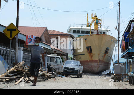 Bewohner bewegen in der Nähe von KM Sabuk Nusantara, die an Land durch den Tsunami in Wani, Oktopus, Central Sulawesi, Samstag (3. November 2018) abgestürzt. Stockfoto