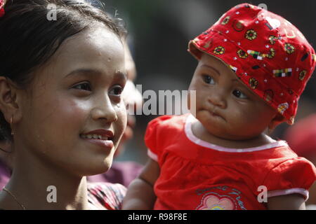 Eine Mutter und Kind melden Sie im Wasser Festival der ethnischen Rakhain Community. Es ist ein Teil ihrer neuen Jahr feier. Jungen und Mädchen werfen Stockfoto