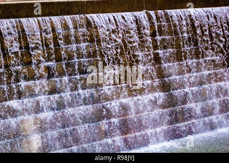 Eine schnelle Aufnahme von klaren Wasser über eine Mauer aus Stein fließende Stockfoto