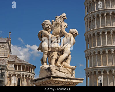 Statue von Putten durch den Schiefen Turm von Pisa (Torre Pendente di Pisa) Pisa, auf der Piazza dei Miracoli (Platz der Wunder) in Pisa, Toskana, Italien Stockfoto