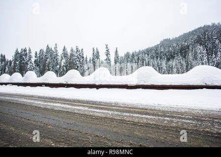 Eine verschneite Leitplanke entlang Interstate Highway 90 auf Snoqualmie Pass, Washington State. Stockfoto