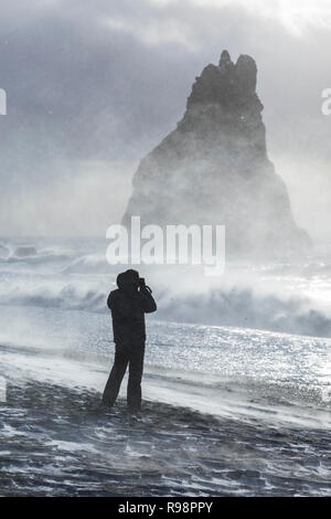 Touristische trotzen die intensive, Gale force Winde entlang der Reynisfjara Black Sand Beach in der Nähe von Vik im Winter in Island [kein Modell Release; f Stockfoto