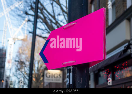 Kunststoff lila Pfeil Schild befestigt, um einen Laternenpfahl mit Kunststoff-kabelbindern in London W1, England Stockfoto