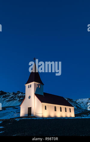 Die wunderschön beleuchtete Vik Kirche steht in der Nähe von Vik, im Winter in Island