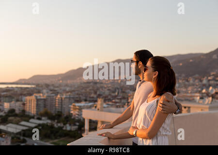 Horizontale Seitenansicht Schoß eines jungen Paares im Sommer Outfit die Stadt genießen und die Aussicht von der Dachterrasse. Kopieren Sie Platz. Stockfoto