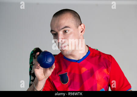 Boccia. Ein behinderter Sportler Sitzen im Rollstuhl mit einem kleinen Ball zum spielen Boccia. Stockfoto