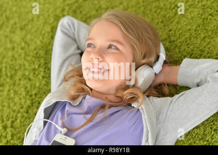 Süße kleine Mädchen in Kopfhörer Musik hören Stockfoto