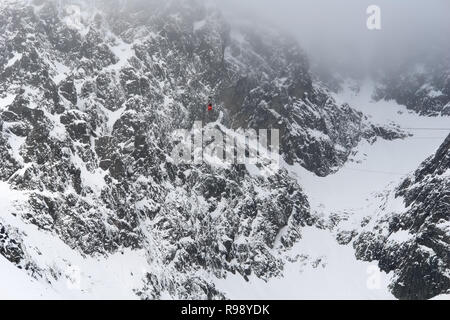 Das rote Kabel auto Kabine auf lomnitzer Stit und weiße Wolke im Winter Hohe Tatra, Tatranska Lomnica, Slowakei. Stockfoto