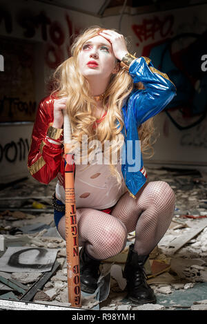 Harley Quinn hockt in einem verlassenen Gebäude Stockfoto