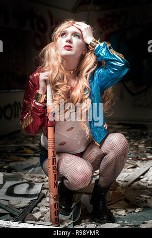 Harley Quinn hockt in einem verlassenen Gebäude Stockfoto