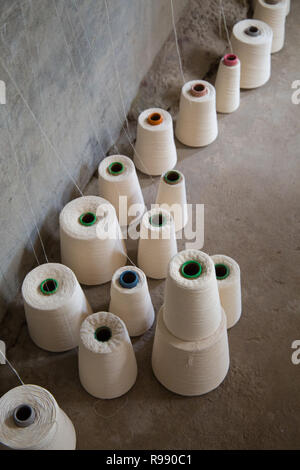 Kegel von Faden aufgereiht auf dem Boden des Weber studio, Ecuador, 2018 Stockfoto