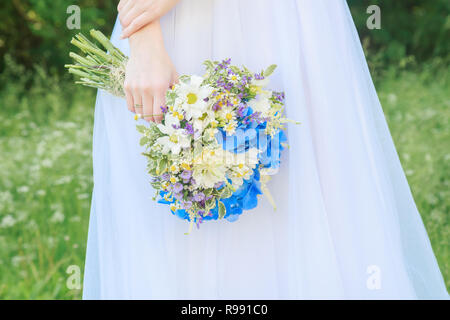 Die Braut in einem Hochzeitskleid hält eine schöne Hochzeit Bouquet. Nahaufnahme Stockfoto