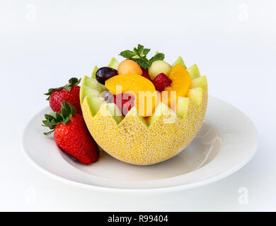 Fancy cut Melone mit sortierten Obst innen auf weißem Hintergrund Stockfoto