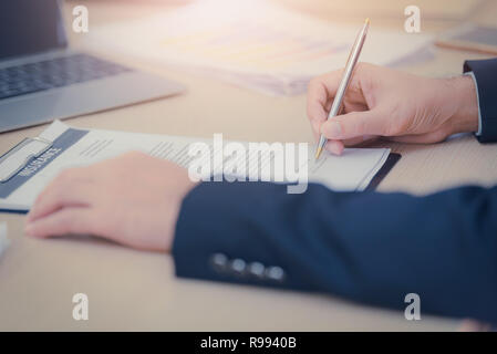 Nahaufnahme der Hände eines Geschäftsmannes mit pen Signieren eines Dokuments im Amt. Vintage tone Stockfoto