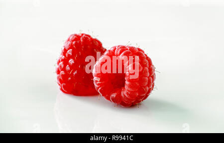 Zwei rote Himbeeren auf weißem Hintergrund Makro Detailansicht Stockfoto