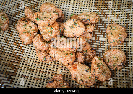 Gebratener Fisch Kuchen. Leckere Fischfrikadellen mit Frühlingszwiebel Gewürze auf Bambus weben. Stockfoto