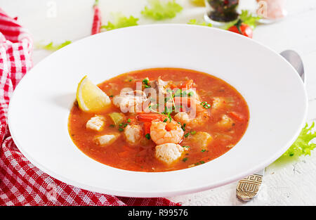 Brasilianische Lebensmittel: Moqueca capixaba von Fisch und Paprika in würziger Kokosnuss Sauce in eine Platte auf eine weiße Holztisch. Brasilianische fisch Eintopf. Stockfoto
