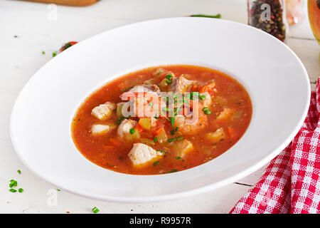 Brasilianische Lebensmittel: Moqueca capixaba von Fisch und Paprika in würziger Kokosnuss Sauce in eine Platte auf eine weiße Holztisch. Brasilianische fisch Eintopf. Stockfoto